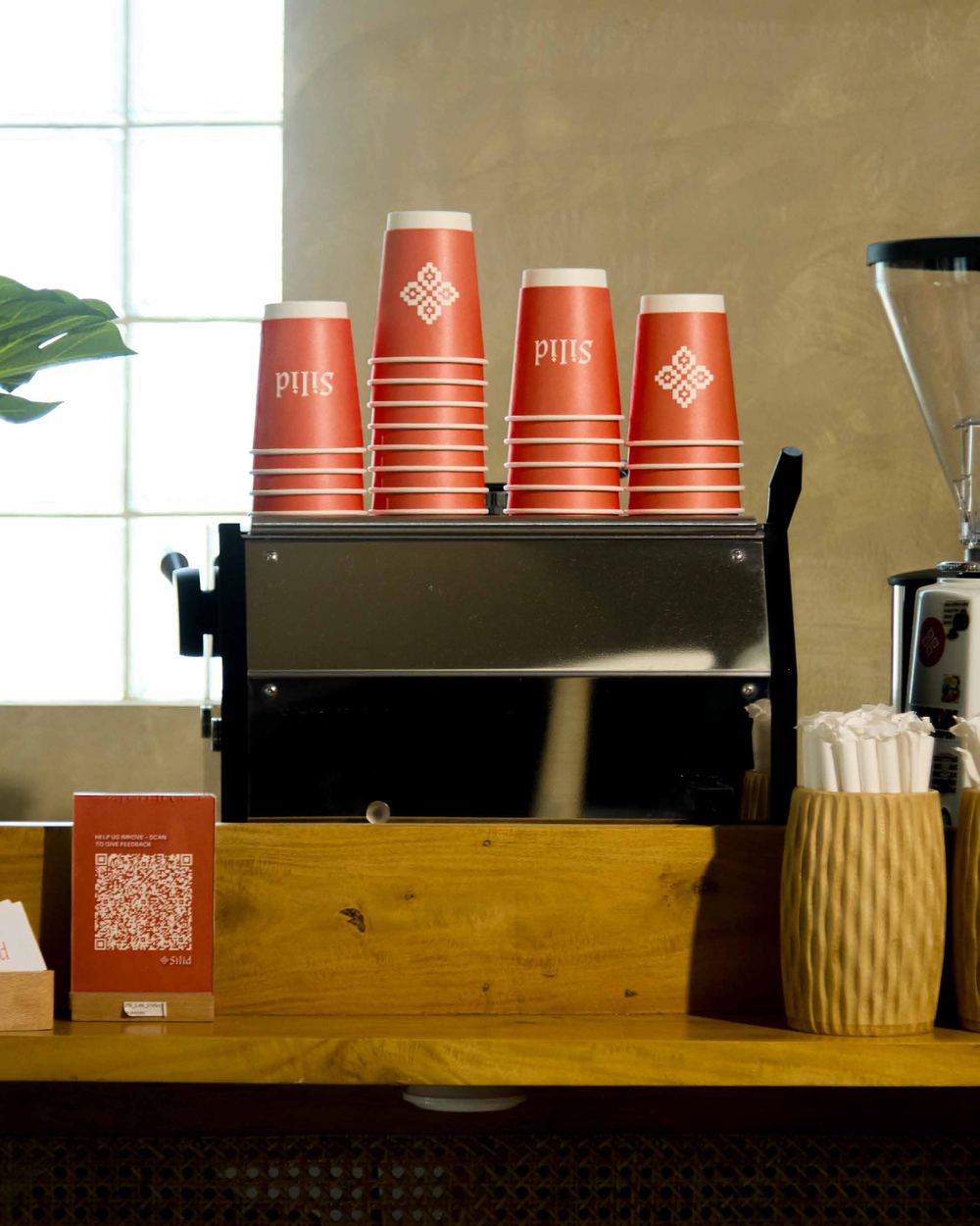 Stacked red Silid paper cups on the Kape Kariton espresso machine
