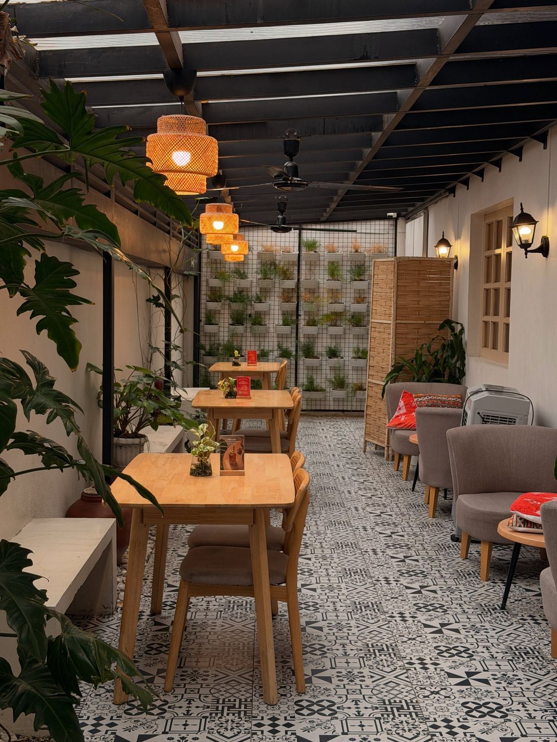 Silid's covered garden walk with patterned tiles, woven pendant lamps and a wall of potted plants