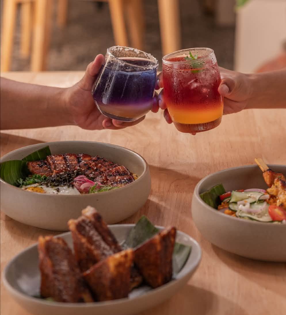 Two friends toasting Kalinaw and Takipsilim iced teas over liempo, inasal and turon toast